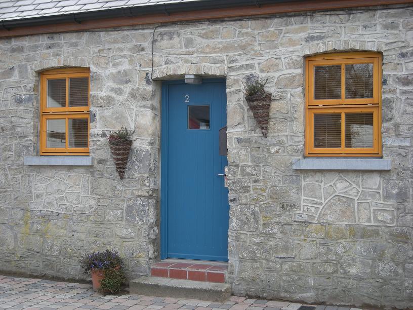 Blue door and pine coloured windows on cottage