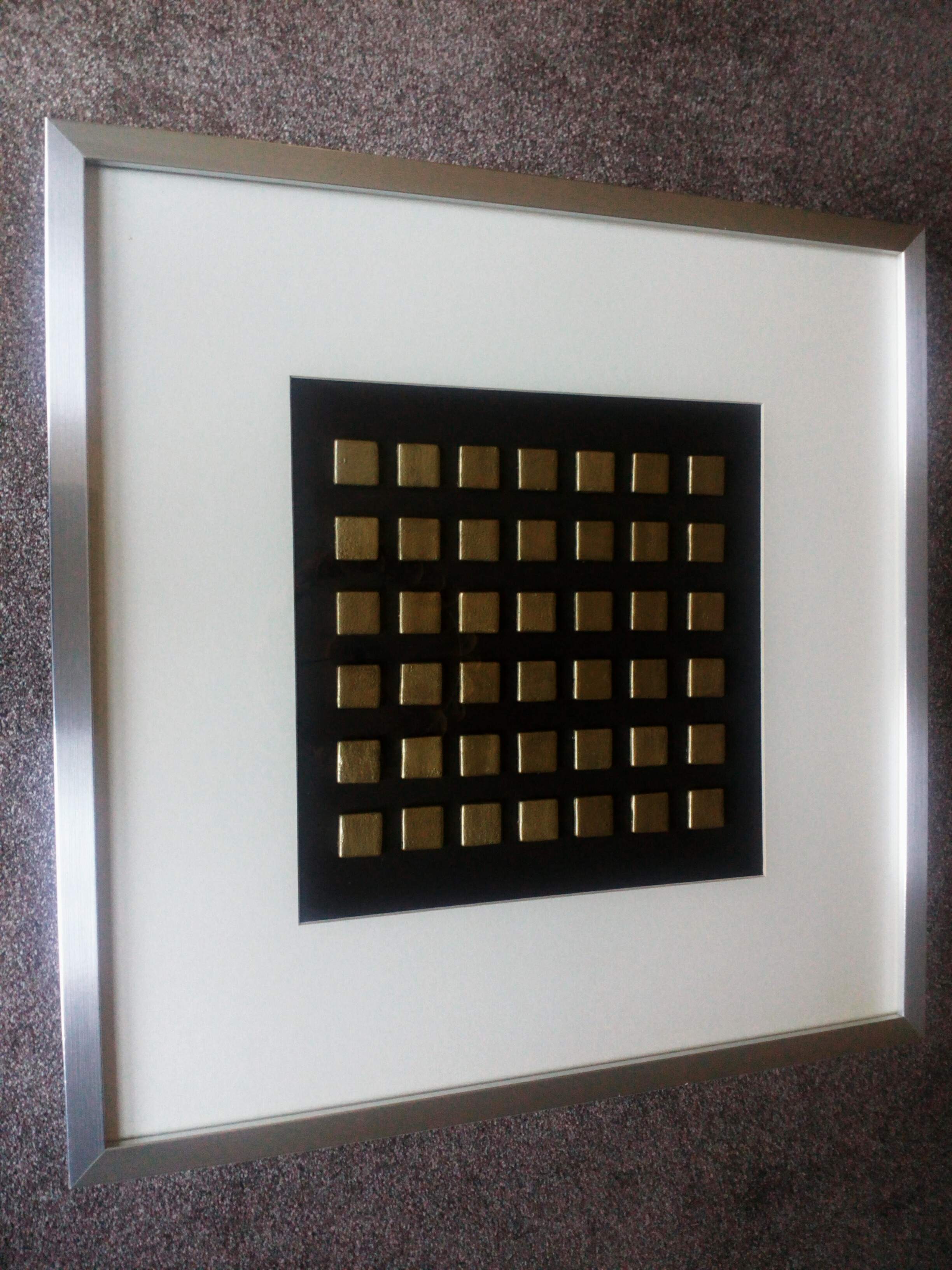 Gold glass tiles mounted on board. Brushed aluminium frame.