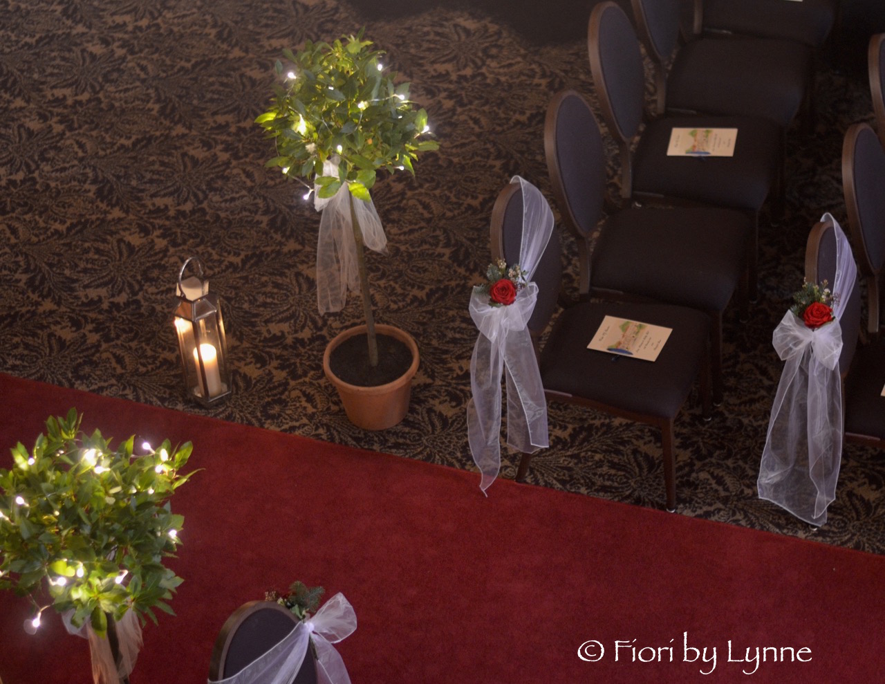 aisle-rhinefieldhouse-winter-chair-flowers-lanterns-baytrees-fairylights.jpg