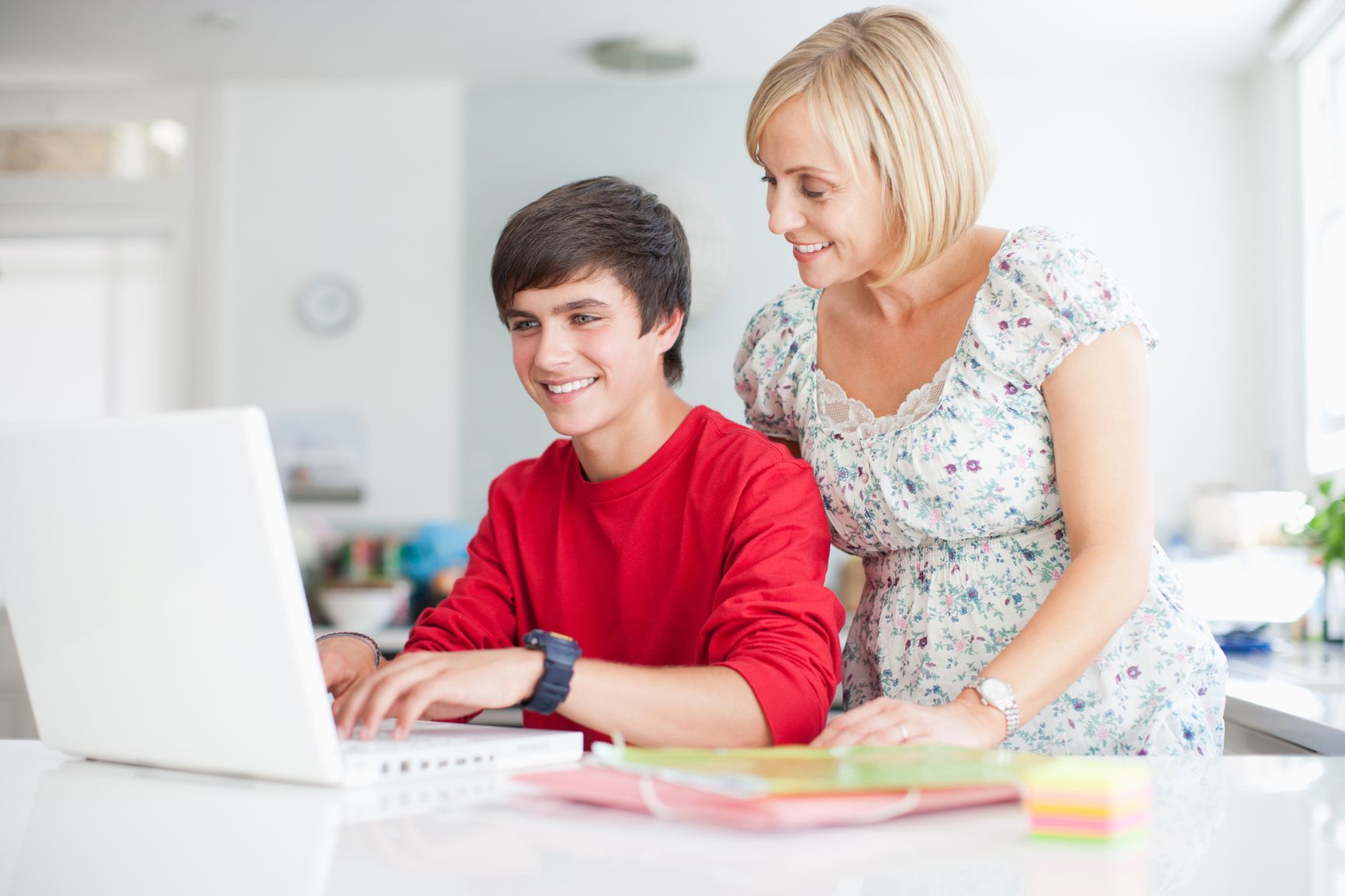 mother-watching-teenage-son-using-laptopjpg