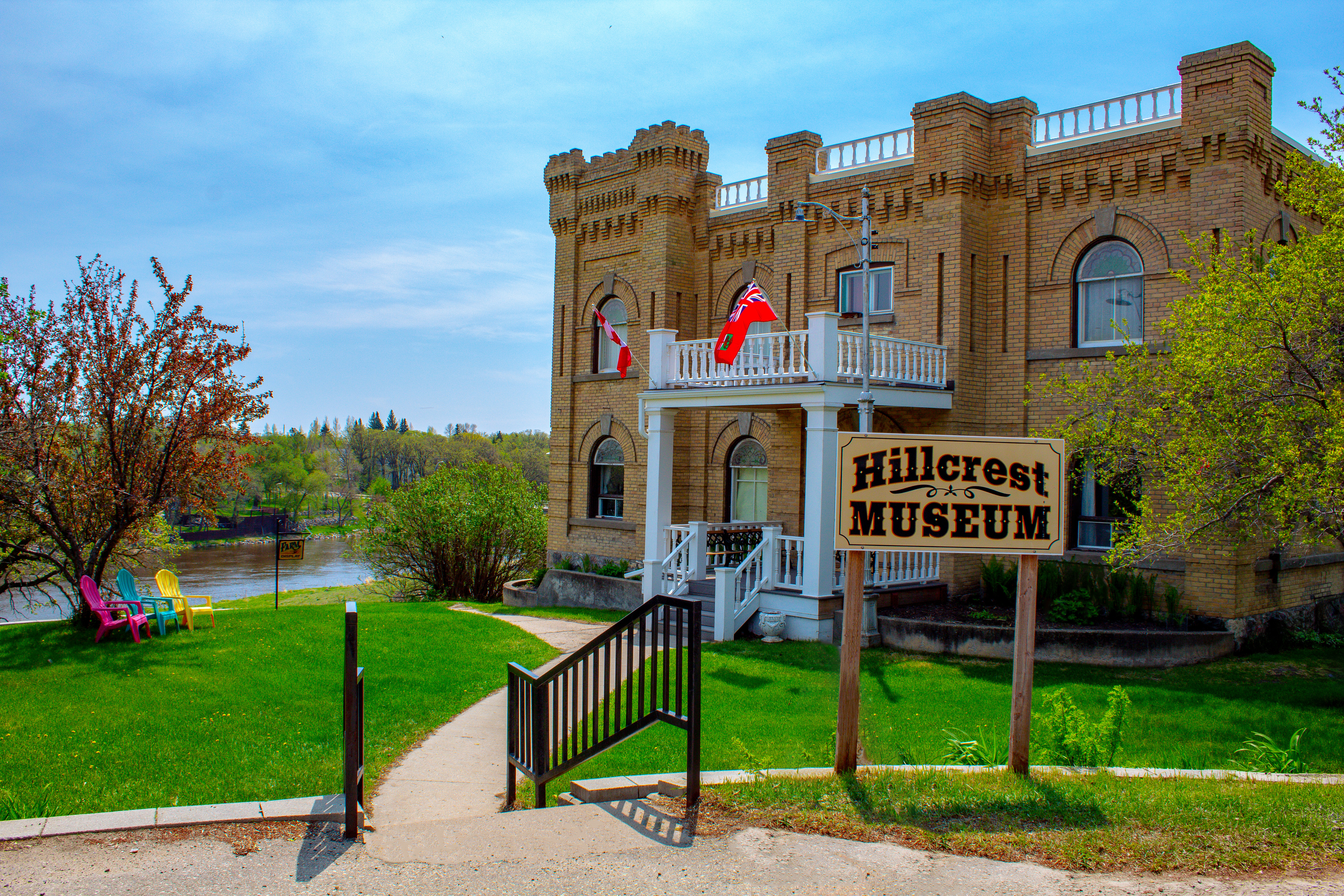 Spring photo of Hillcrest Museum with Souris River in background
