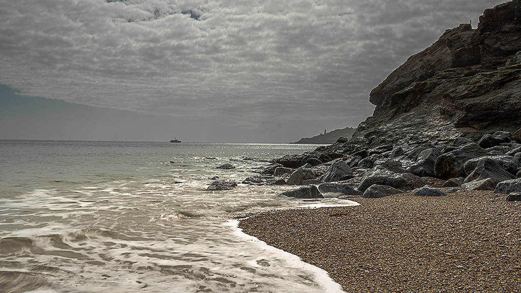 The pebbled beach at Hallsands shimmering with Start Point in the distance. Stock Image ID: 2491