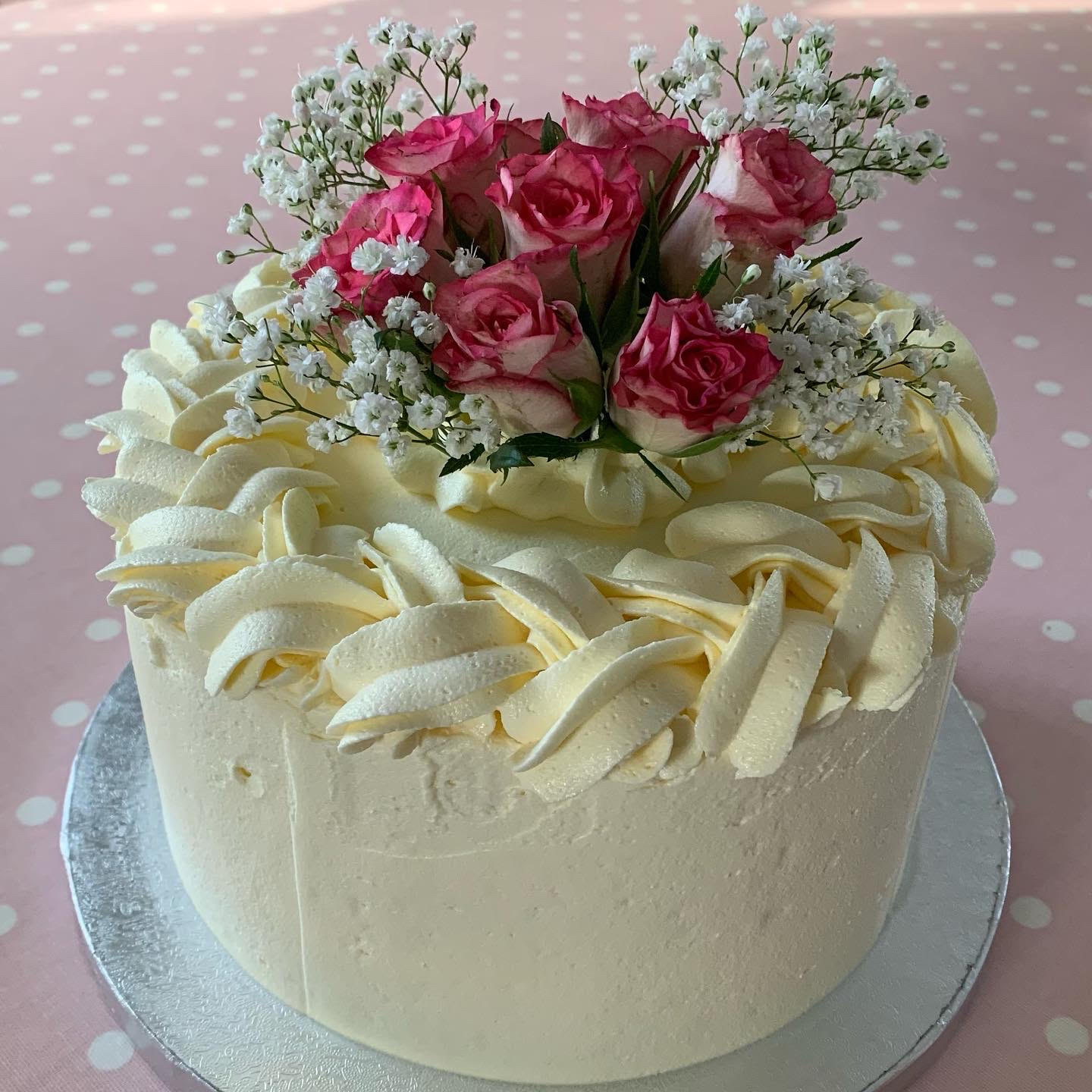 Cake with creamy frosting and pink roses