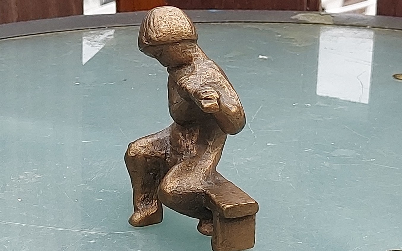 Bronzen beeld van fluitspelende jongen