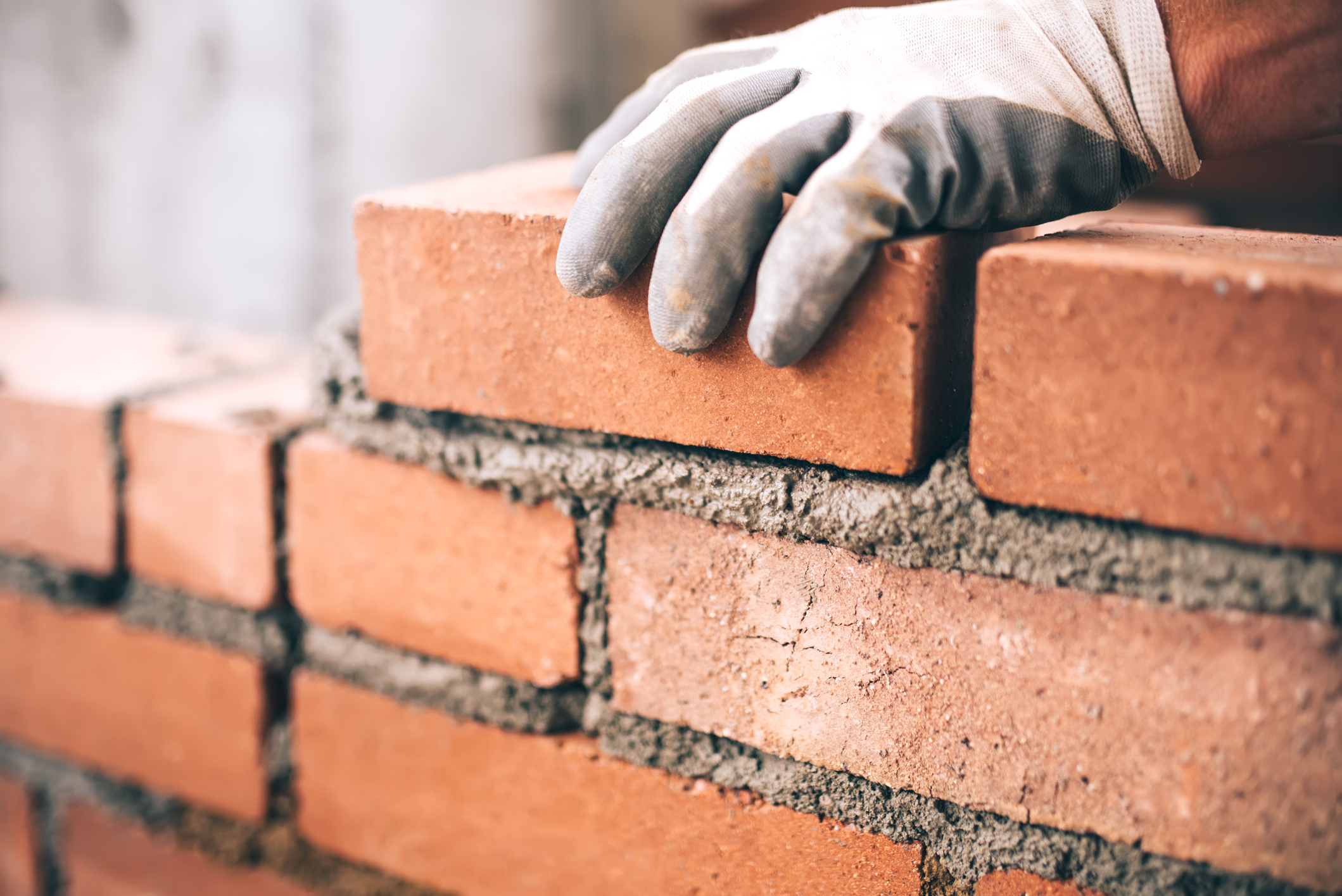 close-up-of-industrial-bricklayer-installing-bricks-on-construction-sitejpg