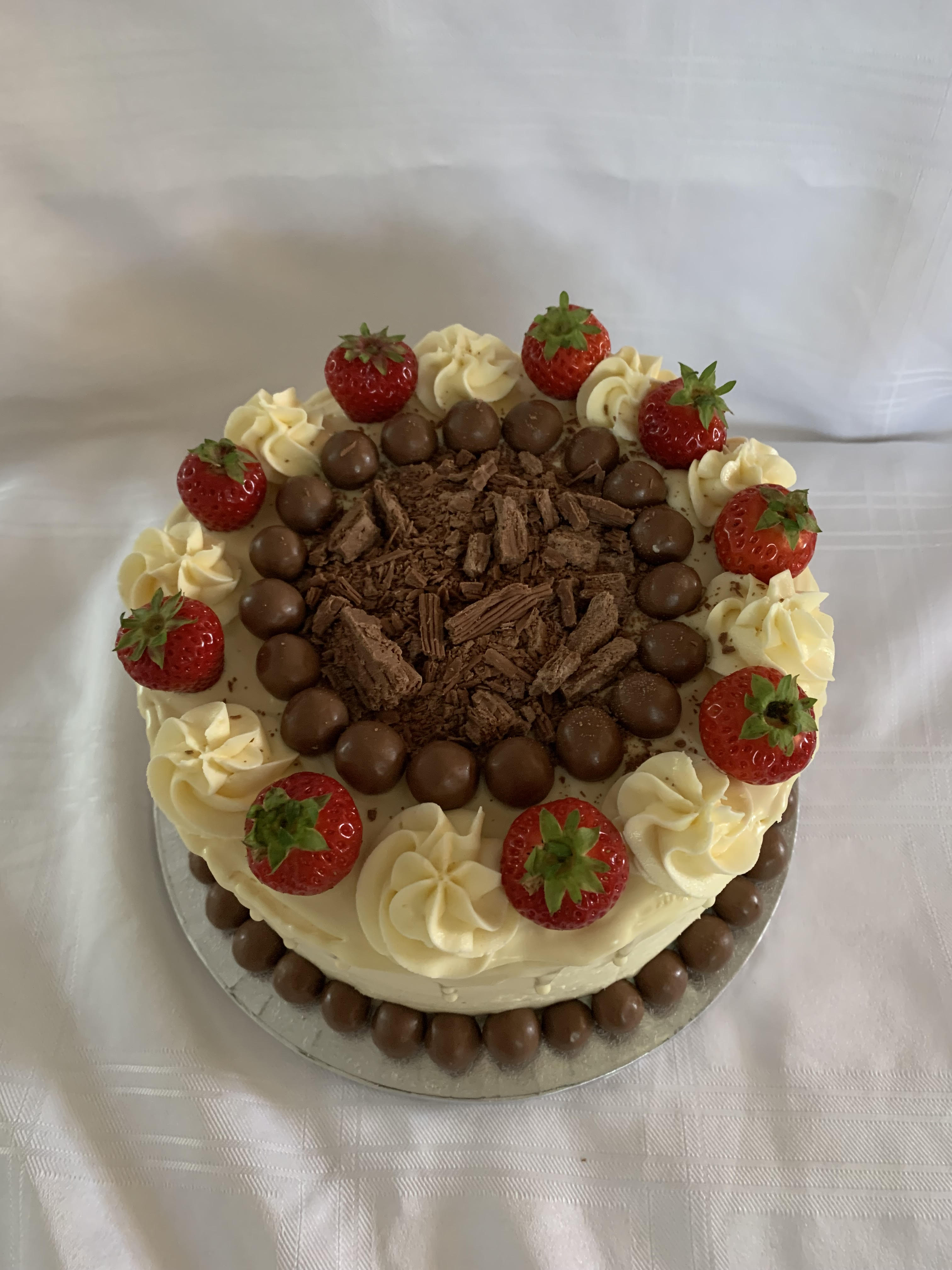 Cake with vanilla frosting, strawberries and lots of chocolate