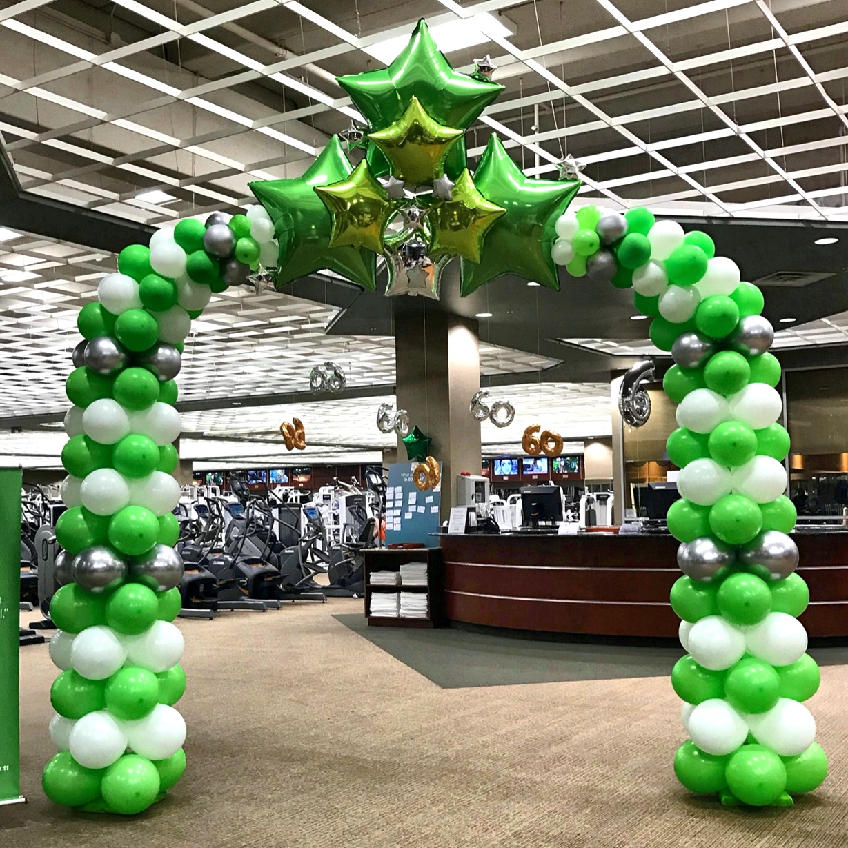 Foil stars are the center focal point of this color blocked lime, white and chrome silver arch.