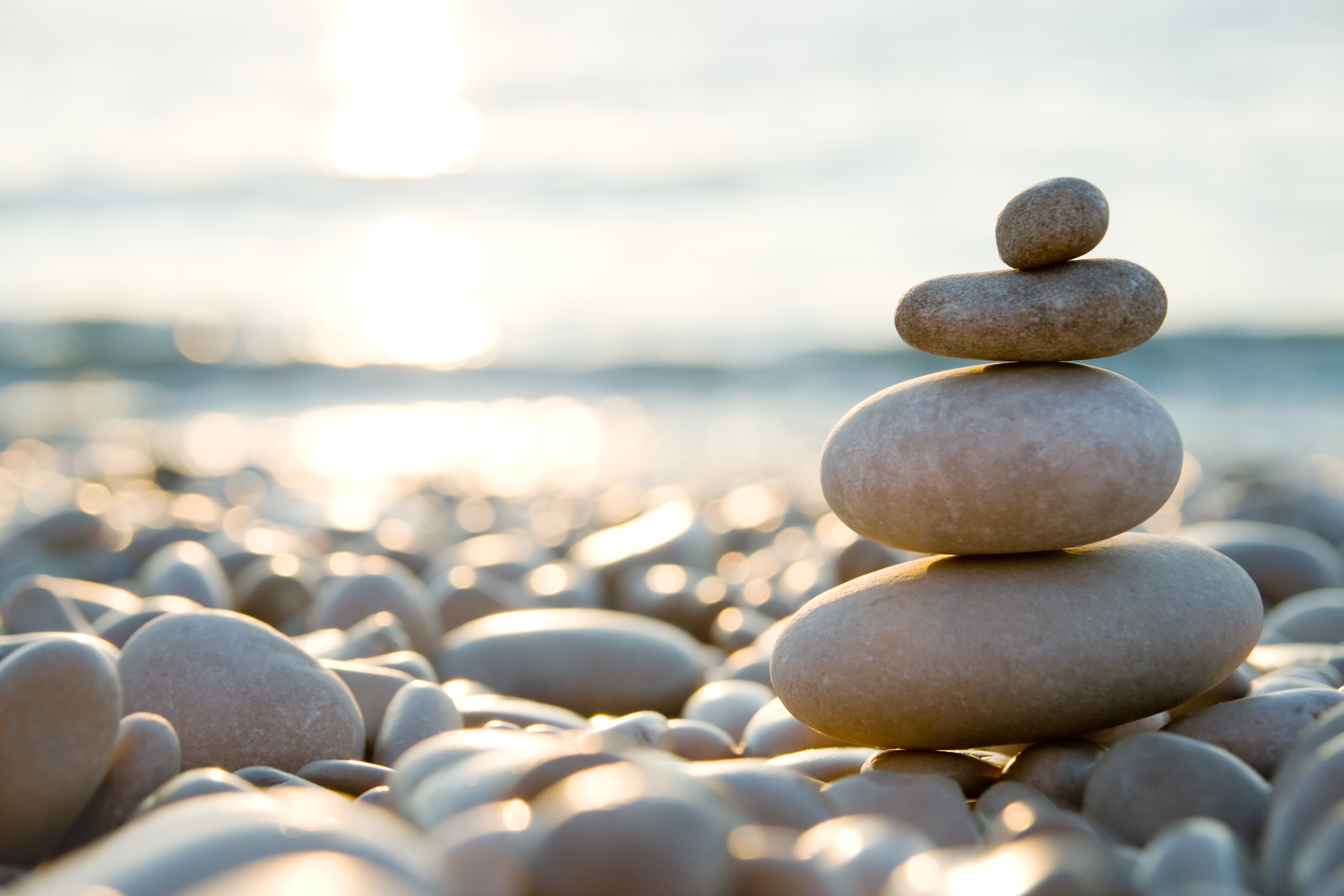 balanced-stones-on-a-pebble-beach-during-sunsetjpg