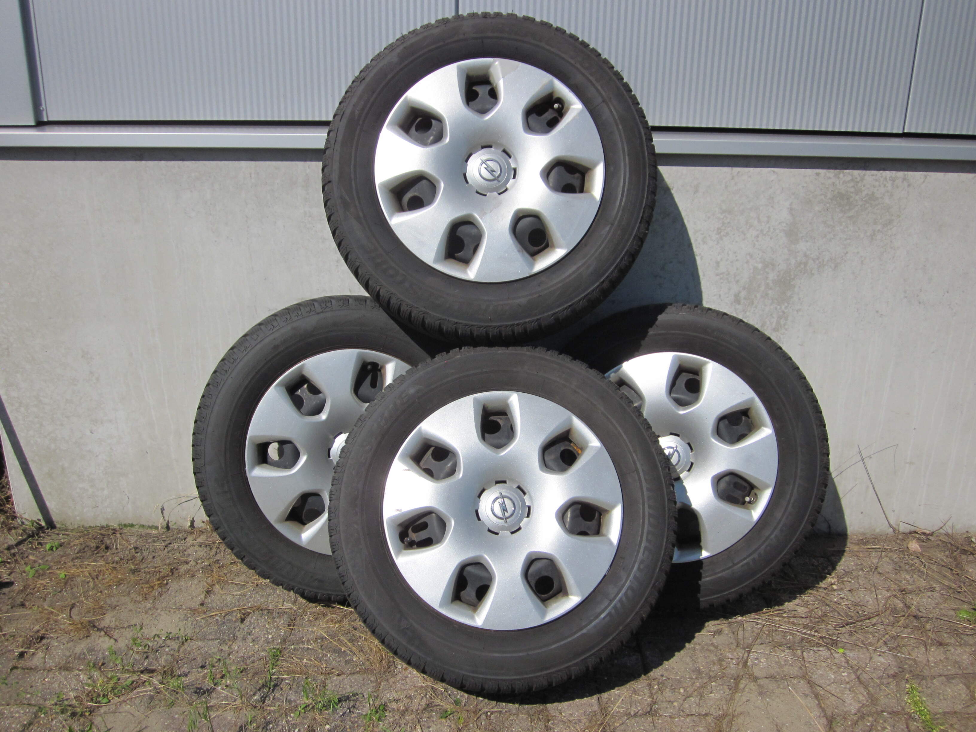 In nette staat Bridgestone winterbanden 215/60/R16 op stalen velg met opel wieldoppen