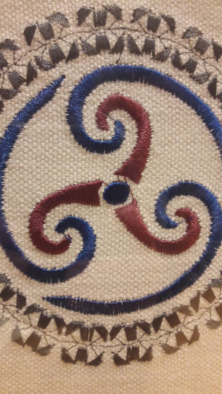 Prachtig geborduurde Triskel in kader achter glas / 31 x 25 cm