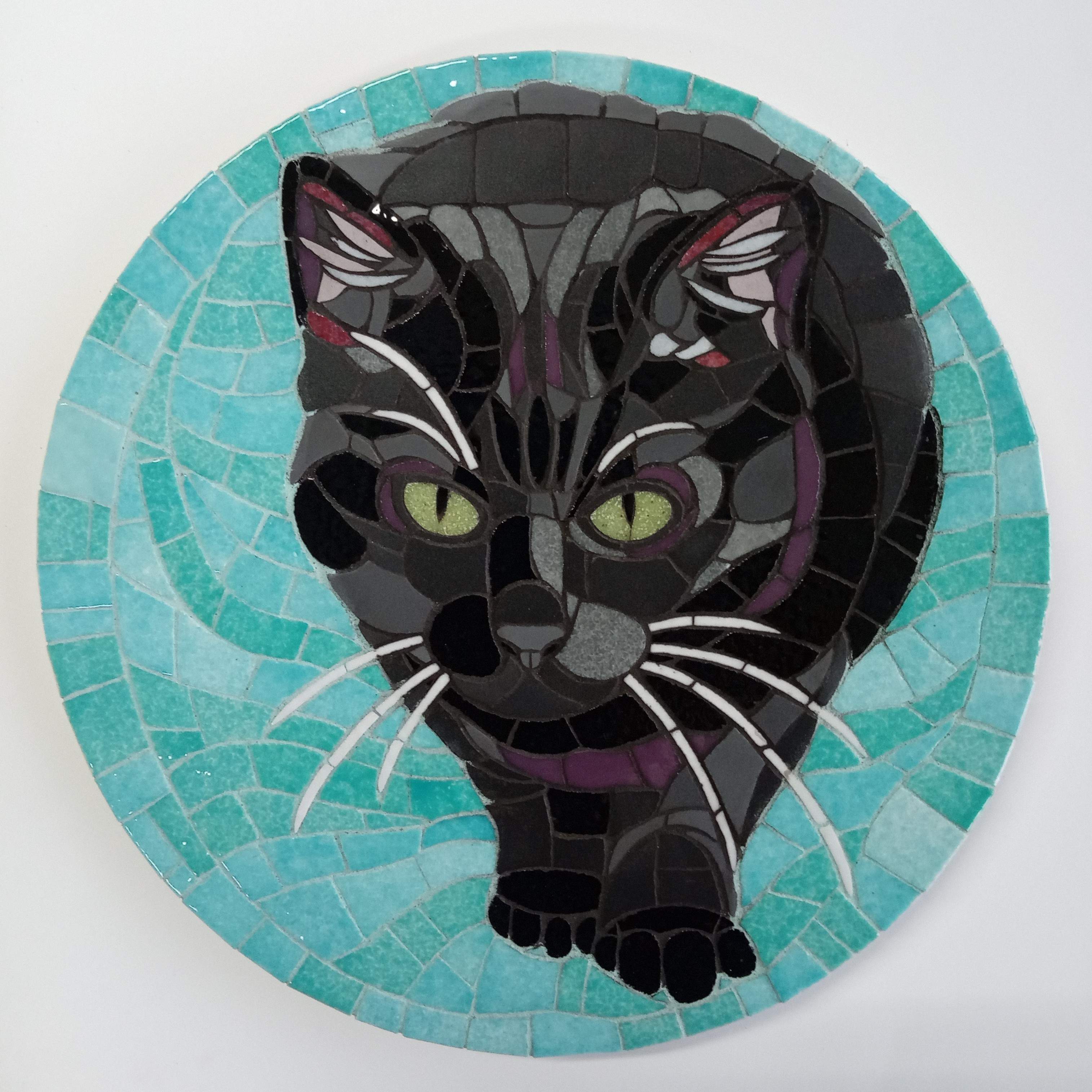 Portret in mozaiek van een zwarte kat met een turquoise achtergrond.