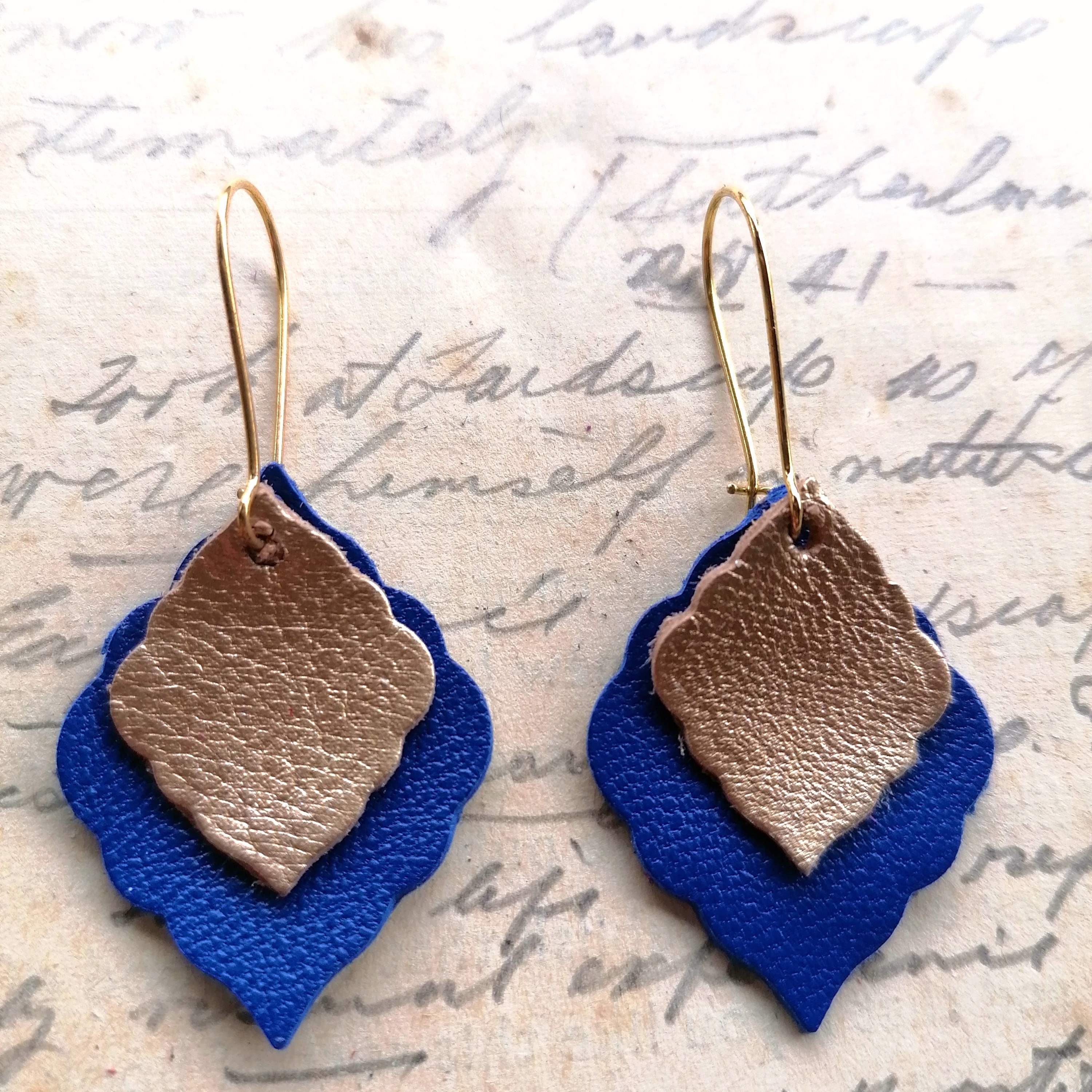 Blue and Gold Leather Earings on long gold closable ear wires on vintage handwritten background