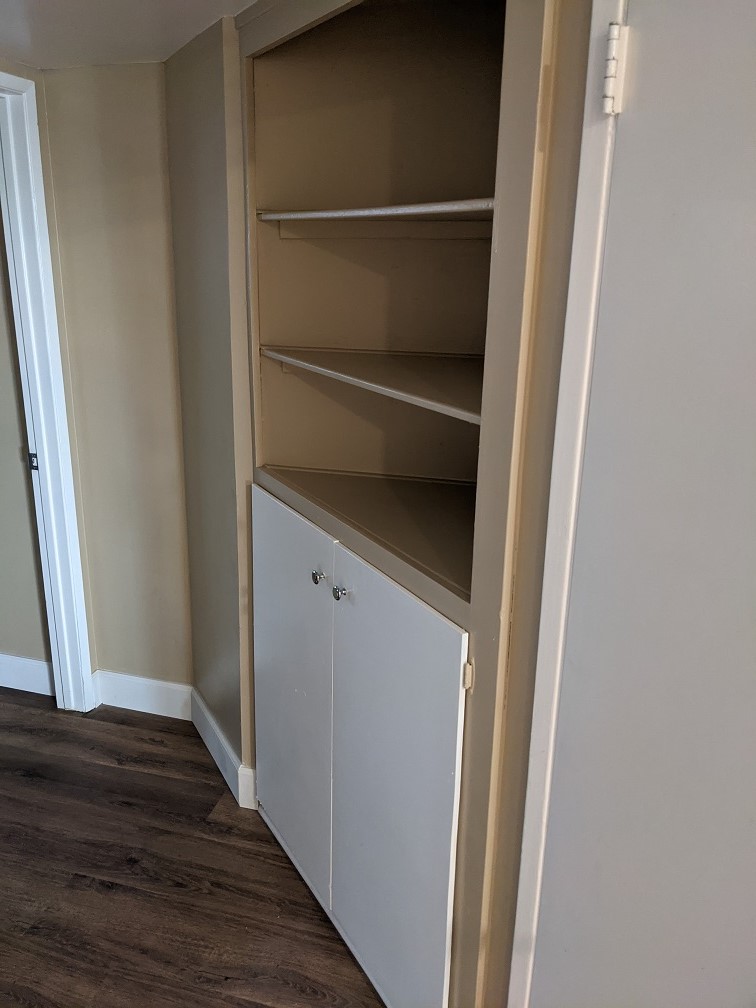 Shelves and a in-built closet is in the hallway, next to the larger utility closet