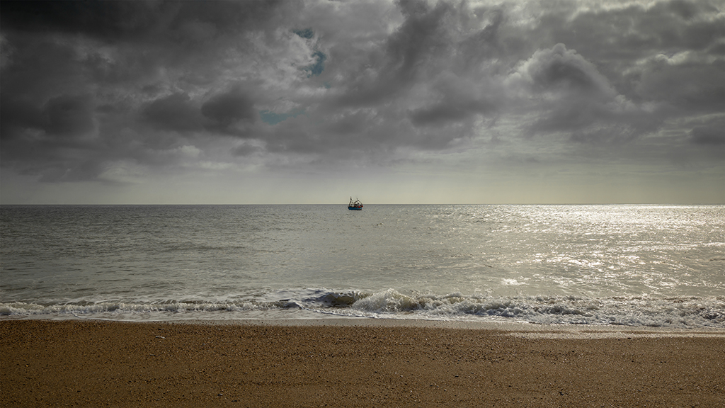 A passing fishing vessel provides a focal point at Hallsands beach. Stock Image ID: 2435