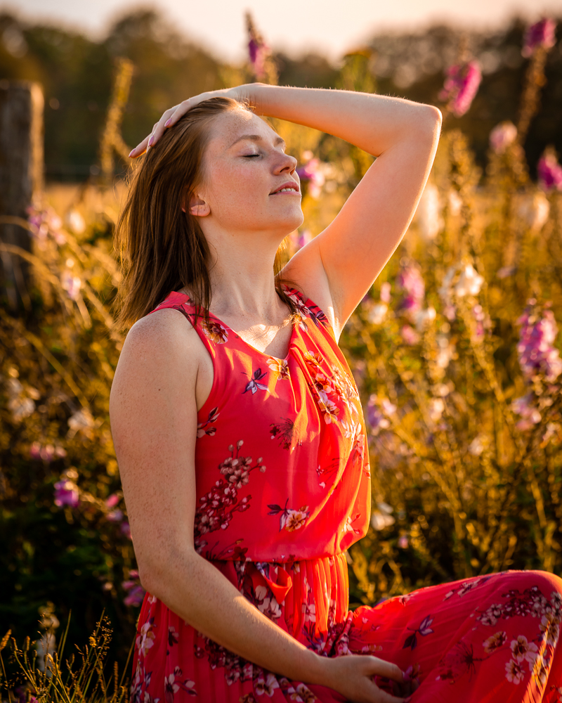 Model Yanah poserend in volle zon voor een berm van bloemen in het Turnhouts Vennengebied.