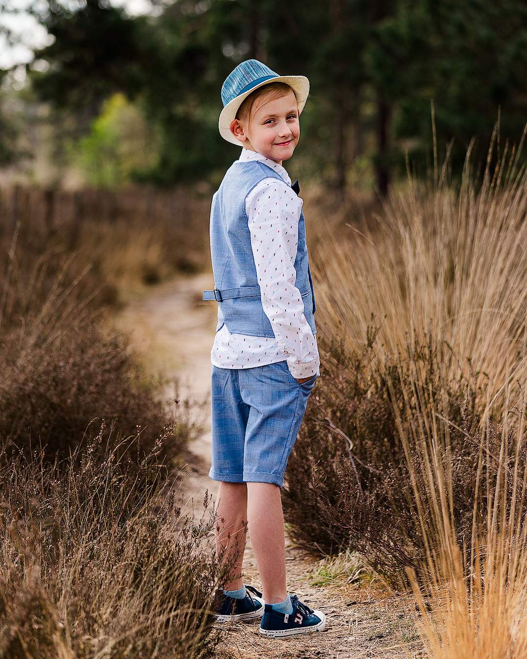 Communiefoto van jongen in korte broek kostuum genomen aan Snepkensvijver in Herentals.