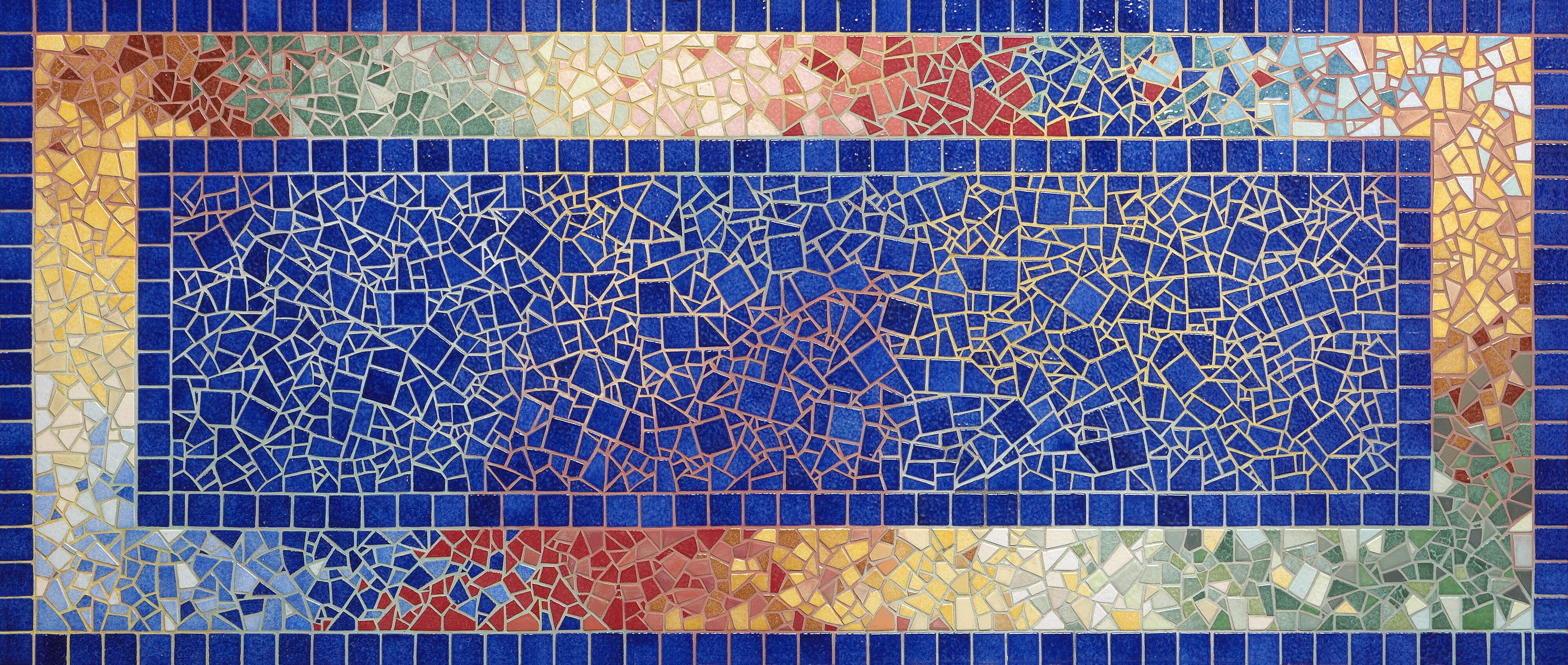 Rechthoekig mozaiektafelblad met blauwe groene, gele, bruine en rode steentjes en gekleurde voeg.