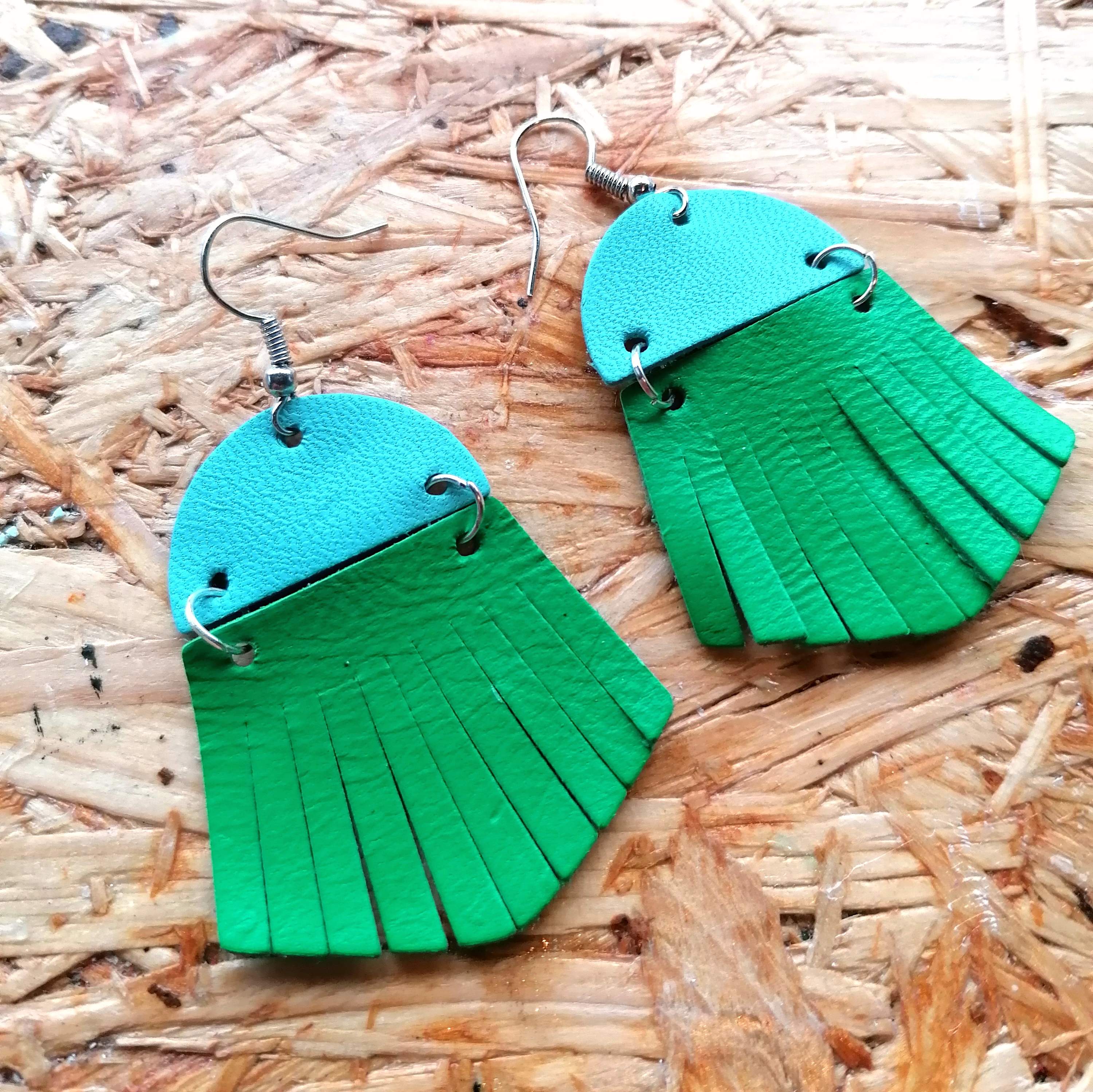 Blue leather semi circle with deep green leather fringe attached by two jump rings. On silver wires