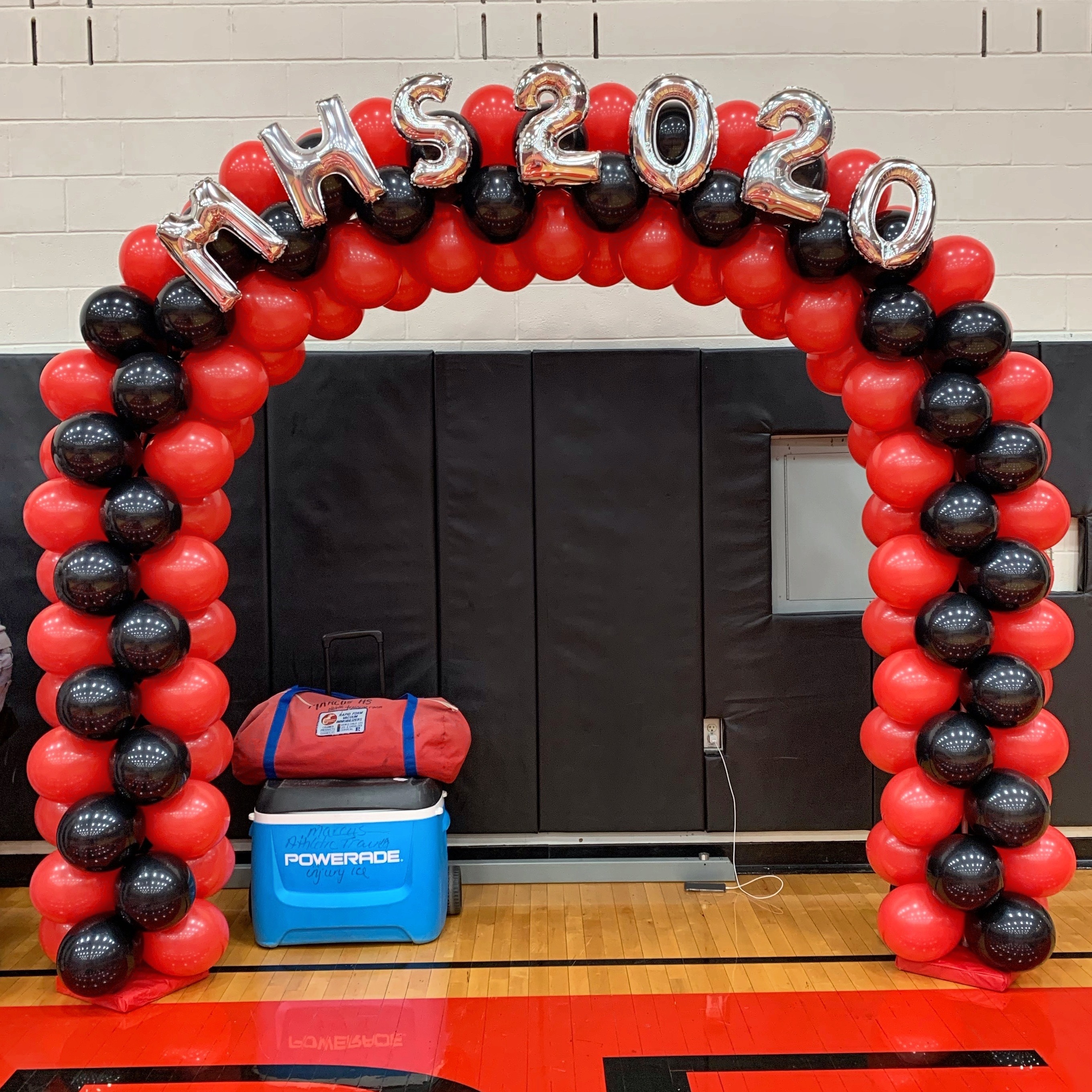 Red and black balloon arch with silver letters and numbers