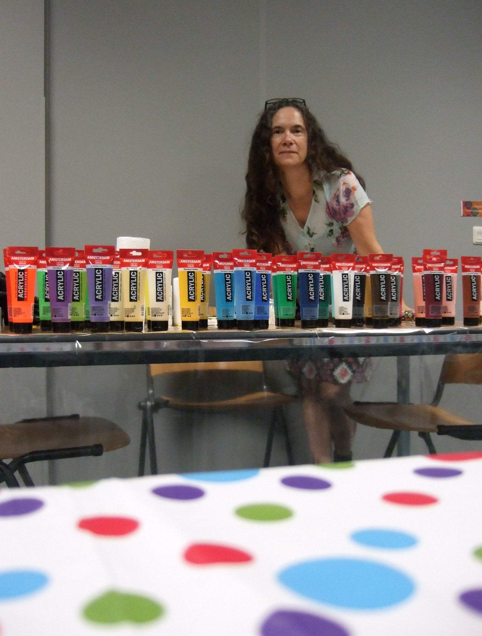Workshop docent Hella Steins toont de vele kleuren acrylverf voor het dot painten.