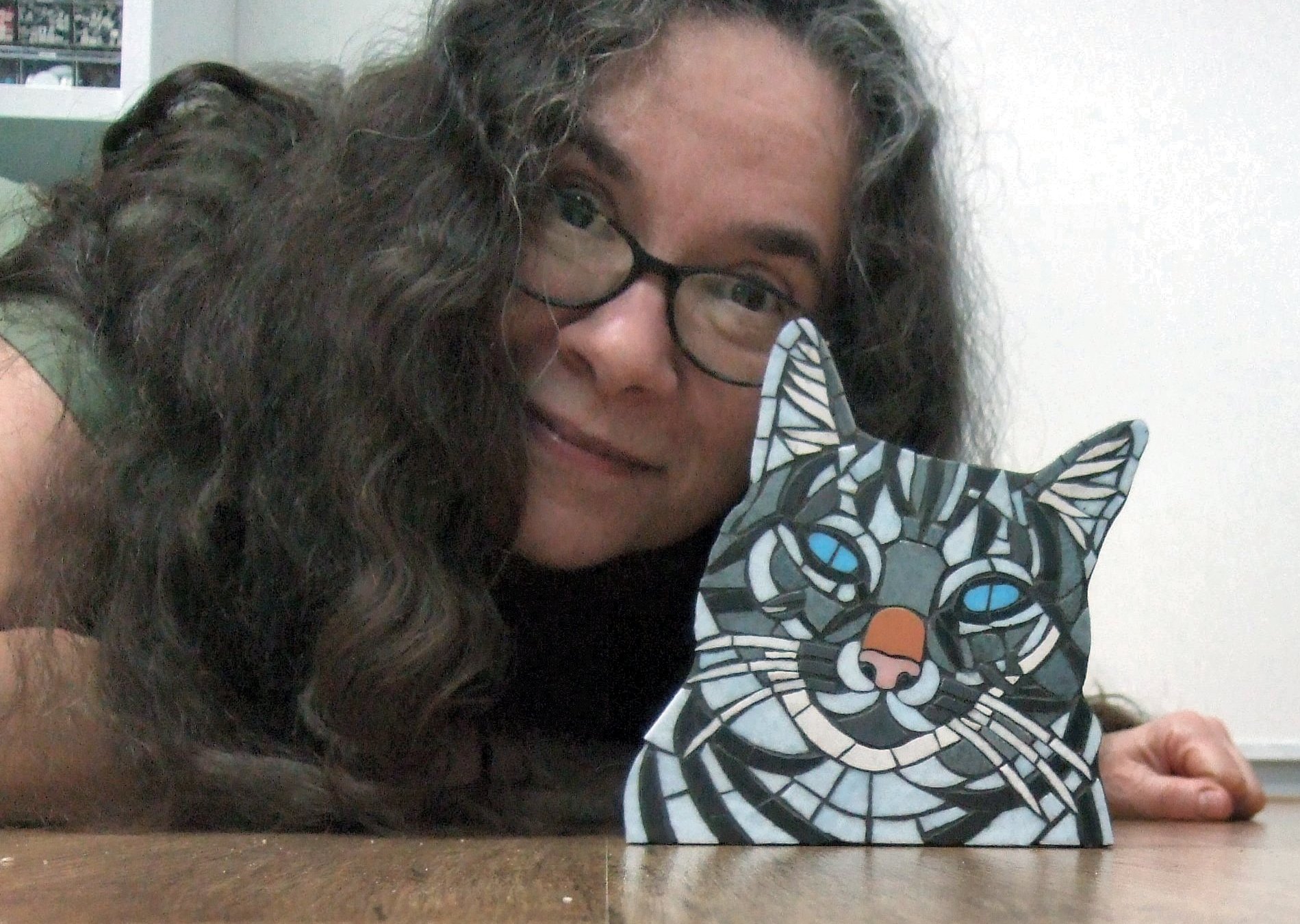 Hella Steins met een mozaiekportret van haar kat Chloe. Een voorbeeld voor de workshop dierenmozaiek