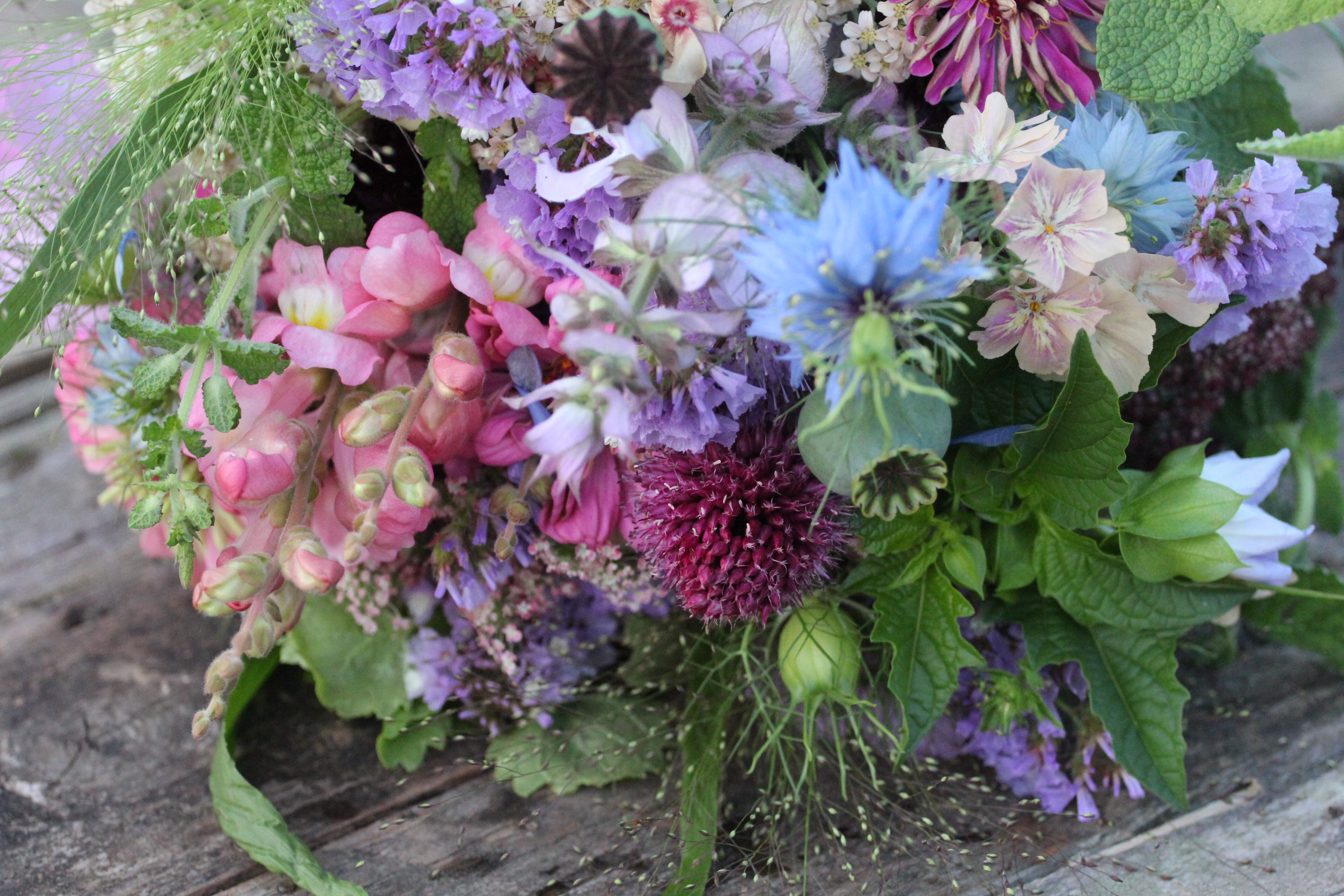 Pink, green and purple wedding bouquet of snapdragons, nigella flowers, statics and mixed foliage