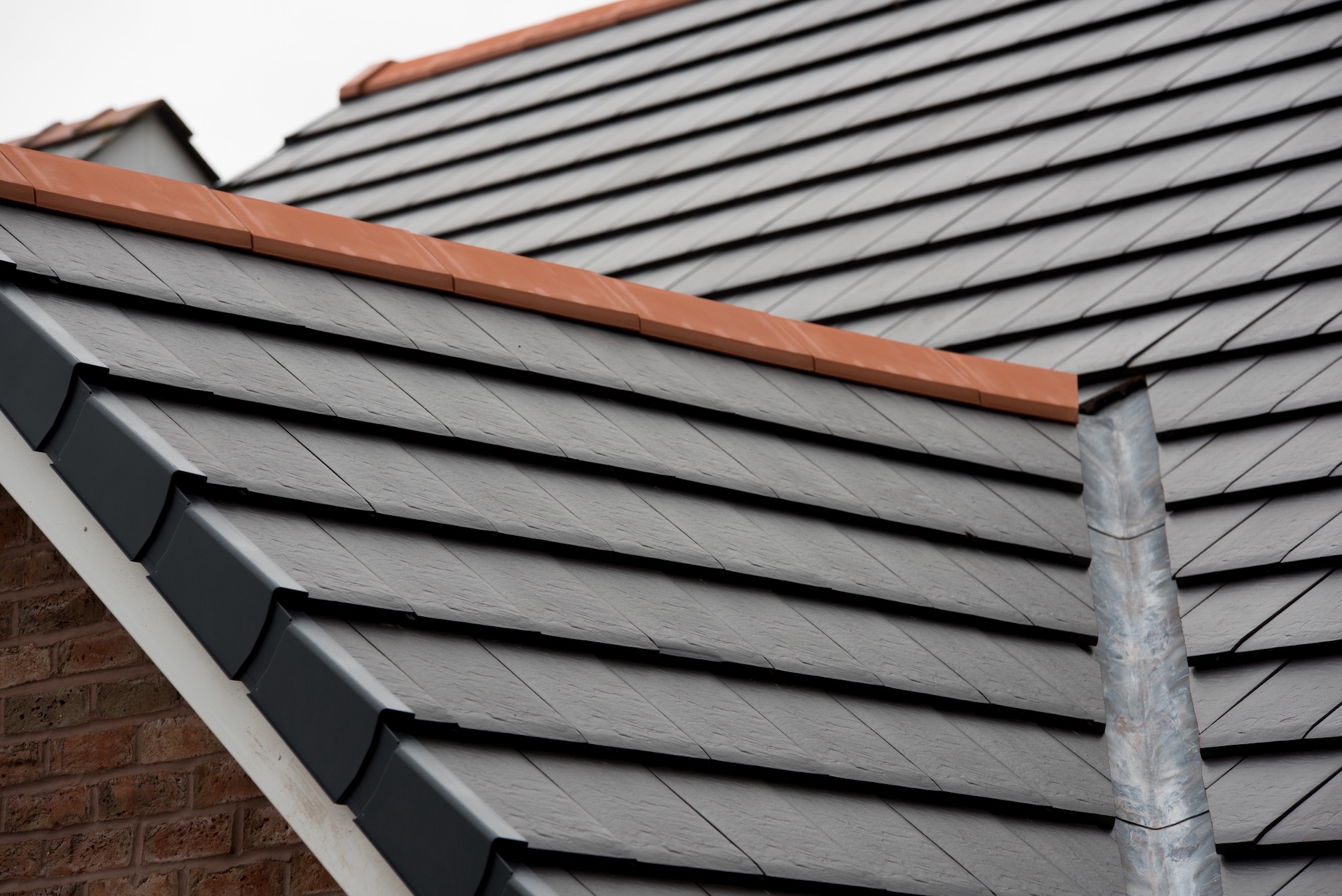 Verea riven slate effect clay tiles, through colour and CS PL2 red clay vented ridge tile