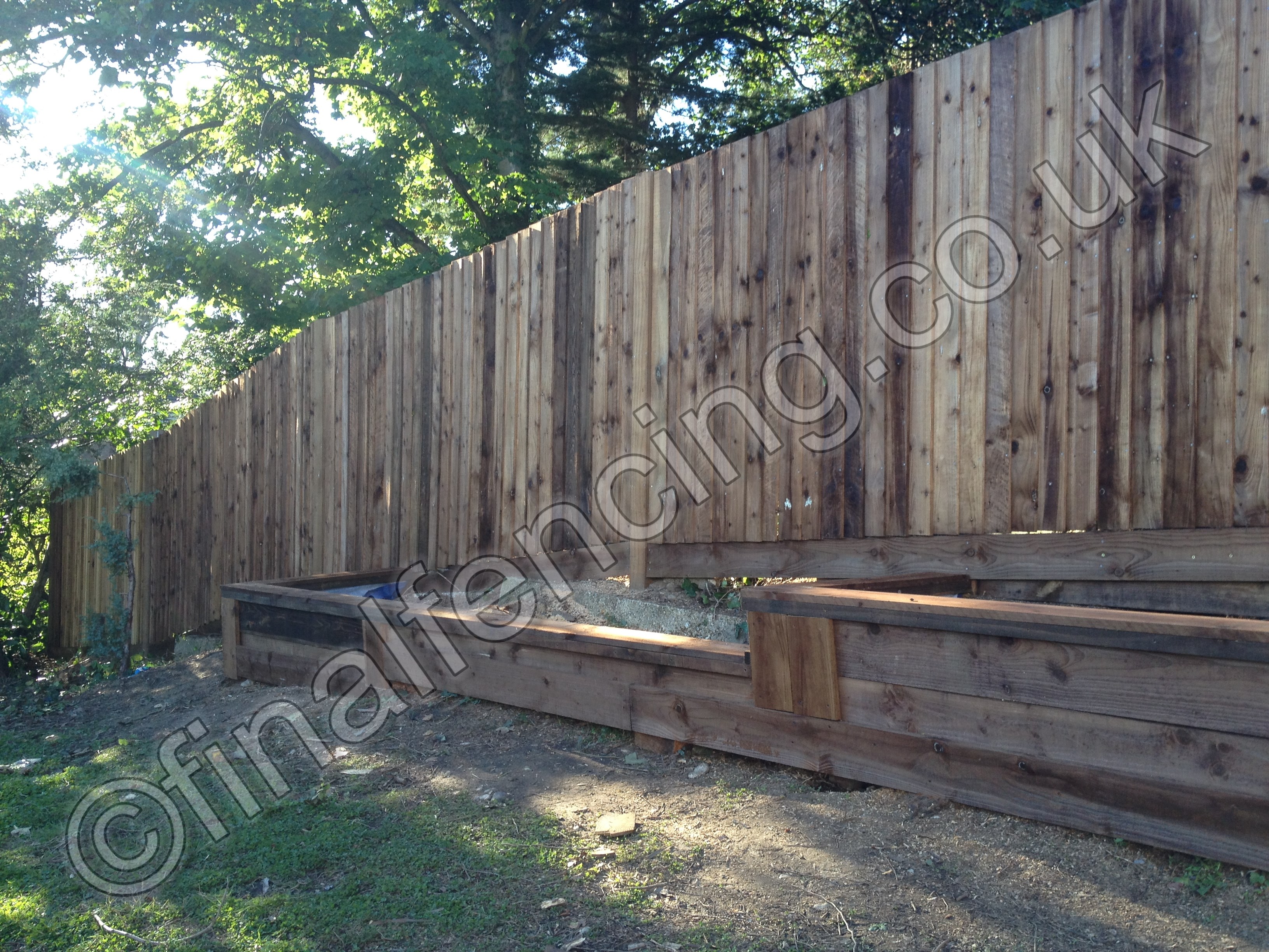 Challenging timber fencing on slope - note sleeper wall not built by Final Fencing