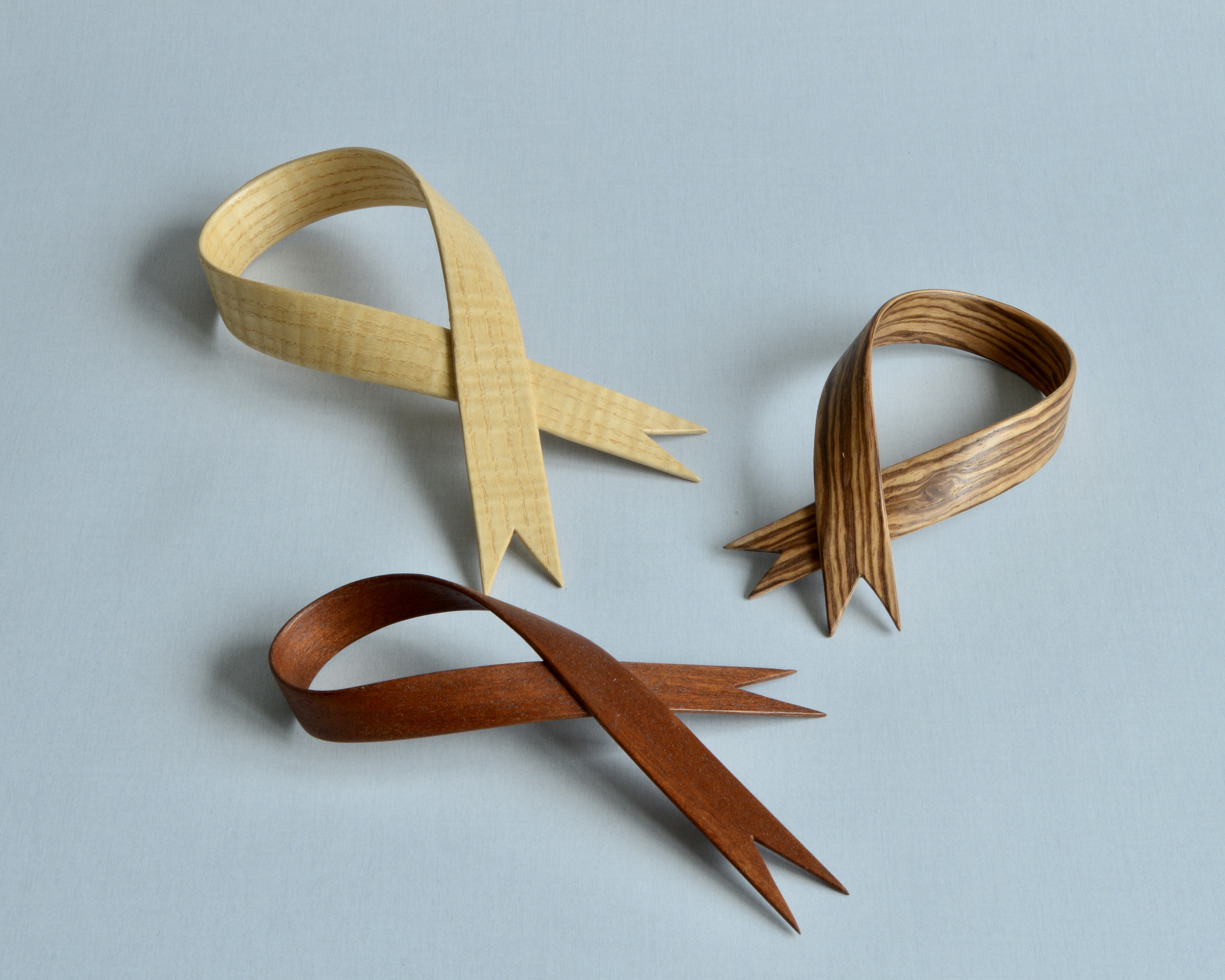 Three Festive 'Ribbon" decorations in a variety of woods