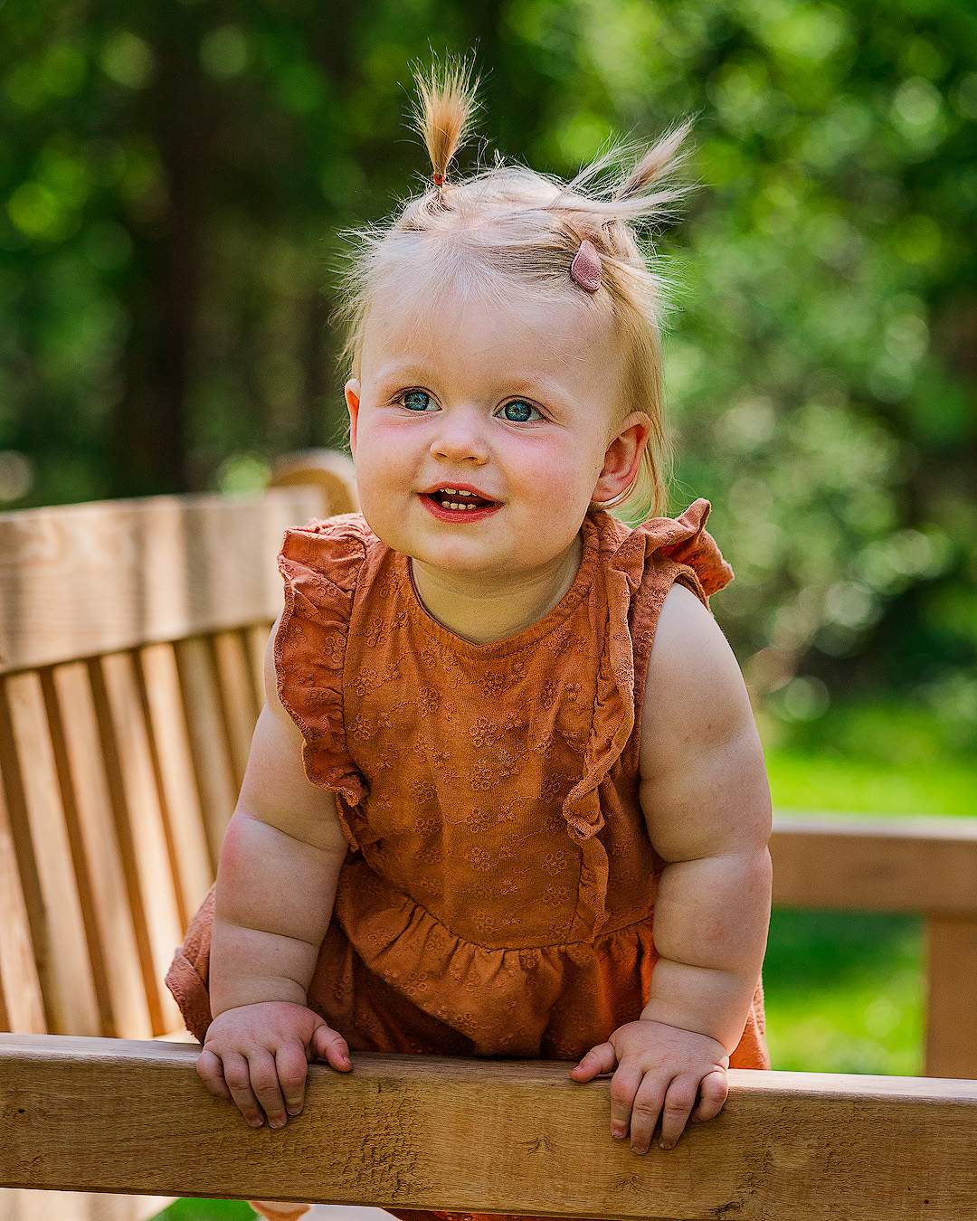 Baby/peuter al klimmend op een bankje in de natuur rondom Oisterwijk