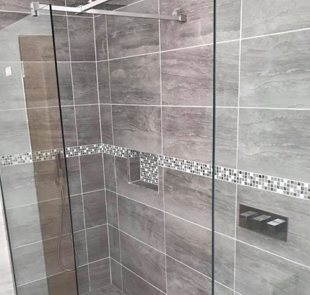 Wet room tiling services Dumfries and Galloway - this example shows a very modern silvery grey colour scheme with a mosaic border and inset panels for soap and other products